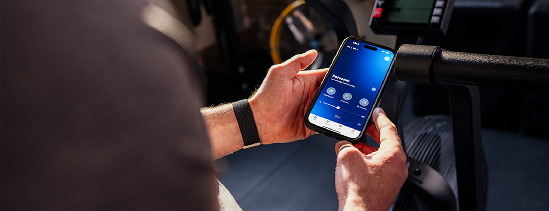 Image of person in a parked car looking at their my starkey app screen
